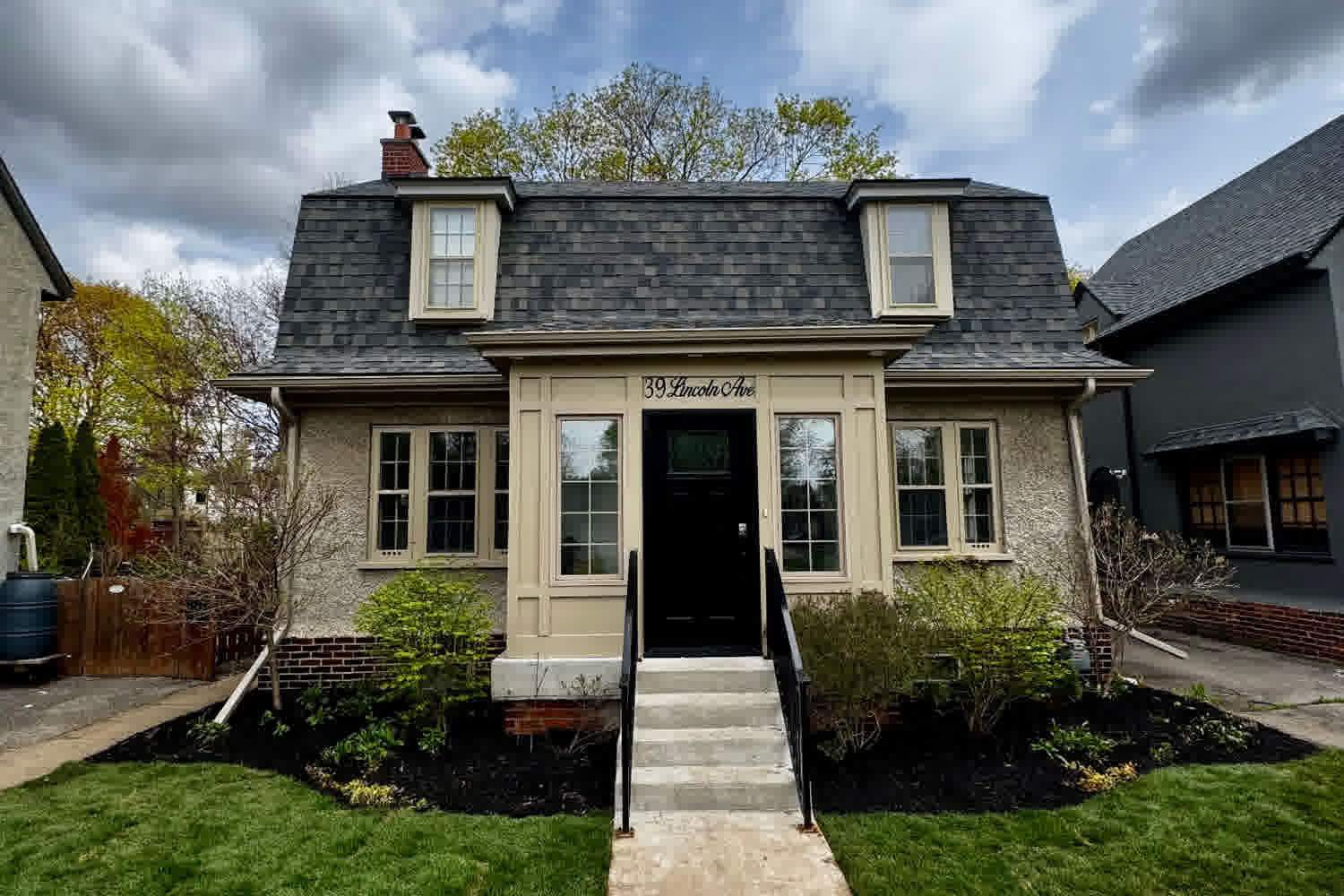Residential front yard with a freshly cut lawn, mulched garden beds and a concrete walkway leading to the front steps in Brantford, Ontario.